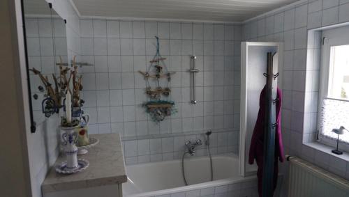 a white bathroom with a tub and a sink at Ferienwohnung Ott in Beerheide