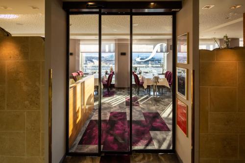 a dining room with glass doors and a dining table at Hotel Am Parkring in Vienna