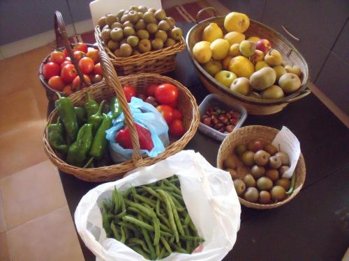 a table with baskets of fruits and vegetables on it at Budiño de Serraseca in Oia