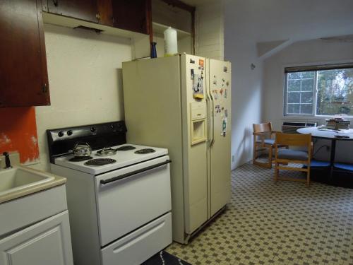 a kitchen with a stove and a refrigerator at Portland Pensione in Portland