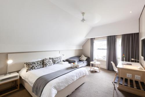 a bedroom with a large bed and a desk at Quarry Lake Inn in East London