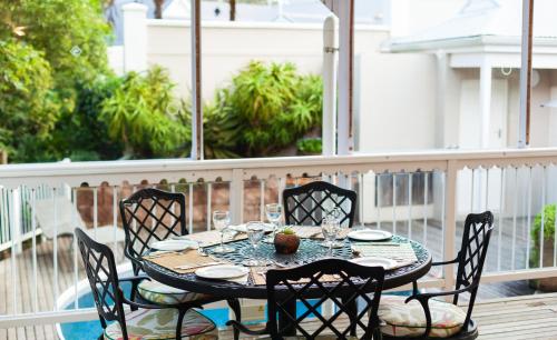 a table on a balcony with a table and chairs at Quarry Lake Inn in East London