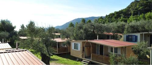 a row of cottages with mountains in the background at Camping Fontana delle Rose in Mattinata