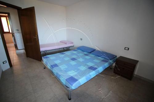a small bedroom with a bed and a cabinet at Appartamento Oleandro Piccolo Gutturu in Marina di Arbus