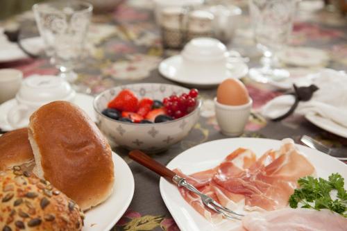 een tafel met borden en een fruitschaal bij Boutique B&B de PASTORY in Zuiddorpe