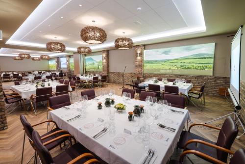 a banquet room with white tables and chairs at Bock Hotel Ermitage in Villány