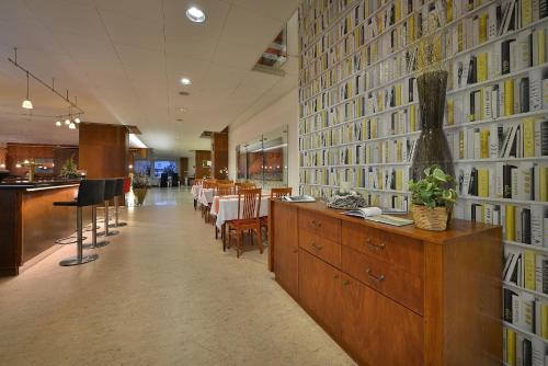 a restaurant with a large wall of books at Hotel Grand Litava Beroun in Beroun