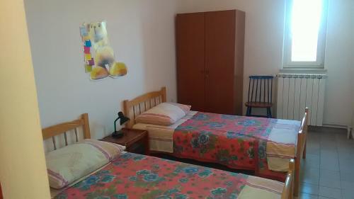 1 dormitorio con 2 camas y ventana en Ema, en Labin