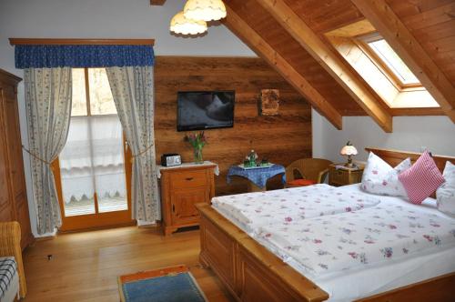 ein Schlafzimmer mit einem großen Bett und einem TV in der Unterkunft Gmiatliche Stubm in Loipersdorf bei Fürstenfeld
