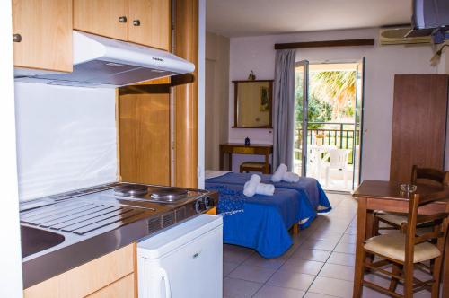 una stanza con cucina e una camera da letto con un letto di Sunshine Studios & Apartments a Stalida