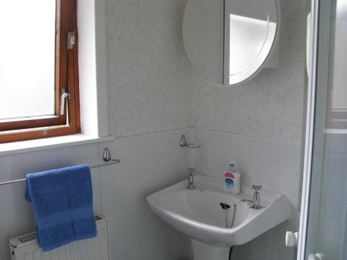 a bathroom with a sink and a mirror at Greenfield Cottage in Thrumster