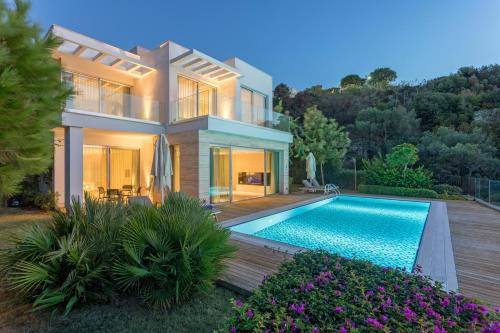 a house with a swimming pool in front of it at Sirene Luxury Hotel Bodrum in Yalıkavak
