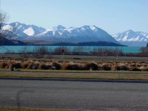 a herd of animals on the side of a road with mountains at Lakeview Tekapo in Lake Tekapo