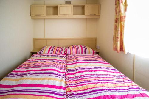 łóżko z paskiem na górze w obiekcie Mobile homes Marina Liptov w Beszeniowej