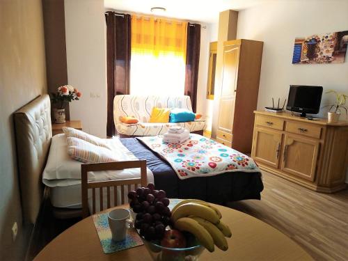 uma sala de estar com uma mesa com fruta em Apartamento Domingo Lozano em Málaga