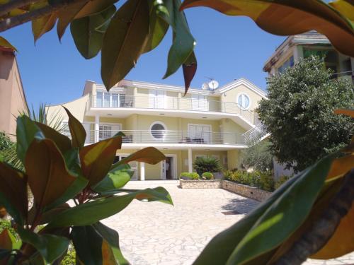 une grande maison blanche avec beaucoup de plantes dans l'établissement Villa Maestral Zadar, à Zadar