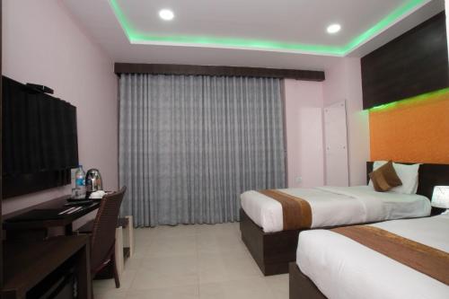 a hotel room with two beds and a desk at Annapurna Hotel in Bīrganj