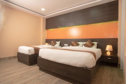 a hotel room with two beds and an orange wall at Annapurna Hotel in Bīrganj