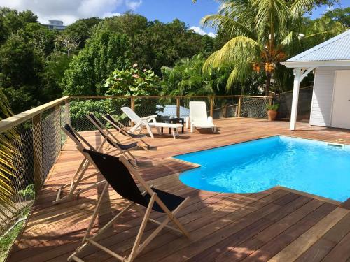 a deck with chairs and a swimming pool at Villa Vue Sauvage in La Trinité