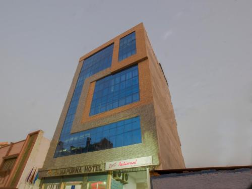 a tall building with blue windows on a street at Annapurna Hotel in Bīrganj