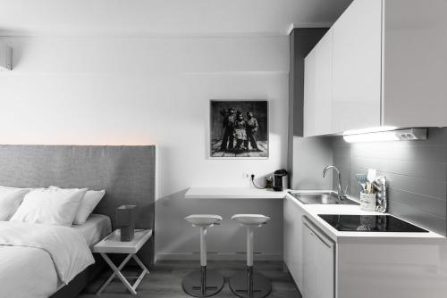 a bedroom with a bed and a kitchen with a sink at M&F Luxury Suites M Suite in Thessaloniki