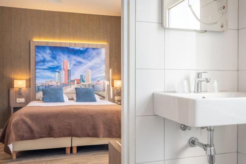 a hotel room with a bed and a sink at Hotel Milano in Rotterdam