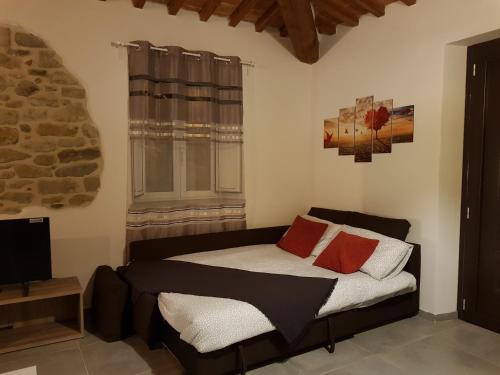 a bedroom with a bed with two pillows and a window at Vicus House in Viciomaggio