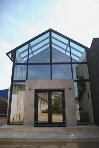 a glass house with a window on a building at Valentino Rooms in Focşani