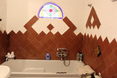 een badkamer met een bad en een glas-in-loodraam bij Punto Relax in La Spezia