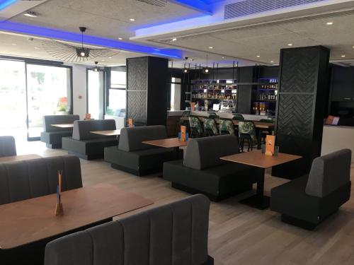 a restaurant with tables and chairs and a bar at Golden Port Salou & Spa in Salou