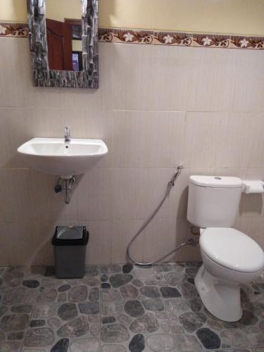 a bathroom with a toilet and a sink at Wirya House in Ubud