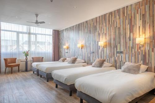 a row of beds in a hotel room at Hotel Milano in Rotterdam