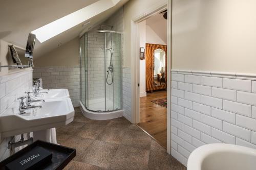 a bathroom with two sinks and a shower at Tolcarne Beach Colonial Restaurant and Rooms in Newquay
