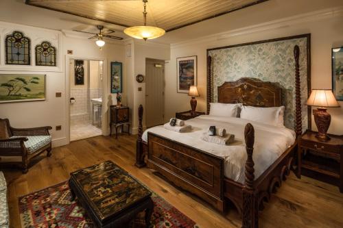 a bedroom with a large bed and a bathroom at Tolcarne Beach Colonial Restaurant and Rooms in Newquay