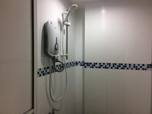 a shower in a bathroom with a shower curtain at Api-Api GuestHouse in Kota Kinabalu