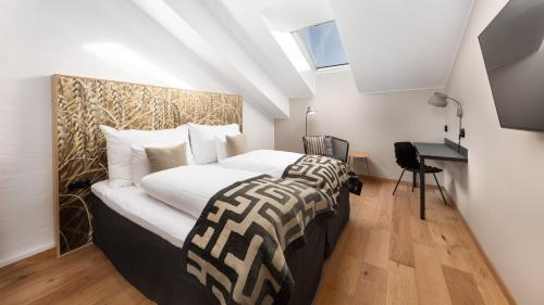 a bedroom with a large bed and a desk at Home Hotel Magasinet in Trelleborg