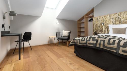 a bedroom with a bed and a desk and chairs at Home Hotel Magasinet in Trelleborg