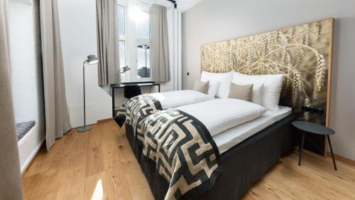 a bedroom with a bed with a large headboard at Home Hotel Magasinet in Trelleborg