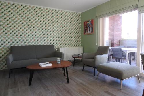 a living room with a couch and chairs and a table at t Sutterhuisje, zalig slapen aan het Donkmeer in Donk