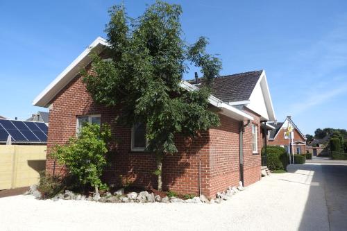 a brick house with a tree on the side of it at t Sutterhuisje, zalig slapen aan het Donkmeer in Donk
