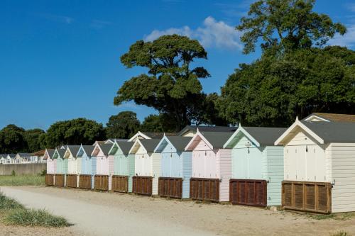 a row of beach huts on the side of a road at Sandhills Apartments, Mudeford in Christchurch