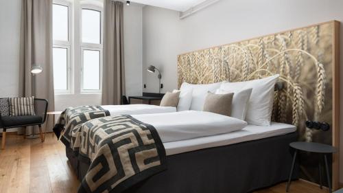 a bedroom with two beds with white pillows at Home Hotel Magasinet in Trelleborg
