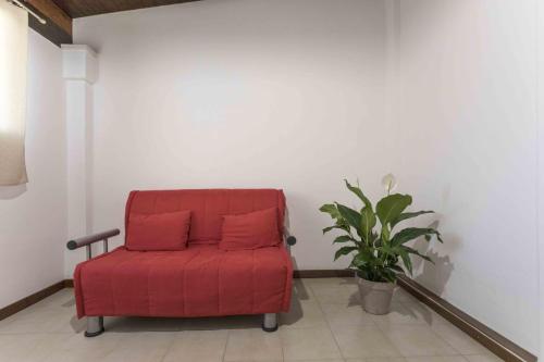 a red chair in a room with a plant at Eloka in Torre Squillace