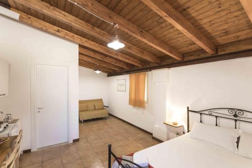 a bedroom with a bed and a couch in a room at Eloka in Torre Squillace