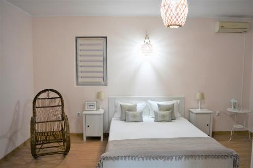 a bedroom with a large white bed and a chair at Casa Rendez Vous in Constanţa
