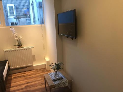 ein Wohnzimmer mit einem Flachbild-TV an der Wand in der Unterkunft Central sweet BNB in Amsterdam