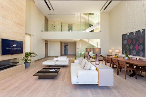 a living room with white furniture and a dining room at Sirene Luxury Hotel Bodrum in Yalıkavak