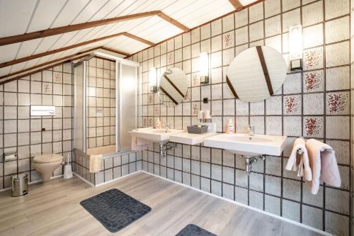 a bathroom with two sinks and two mirrors at Schröder's Hotelpension in Willingen