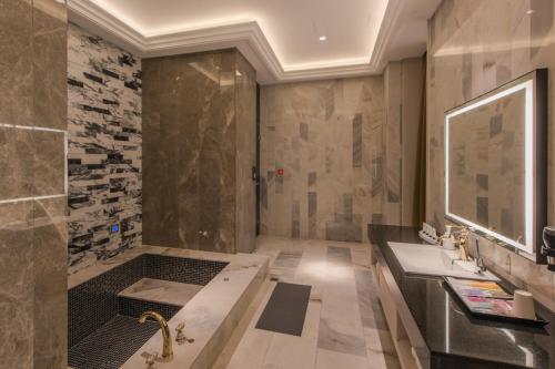a bathroom with a shower and a sink and a tub at Green Palm Motel in Yuanlin