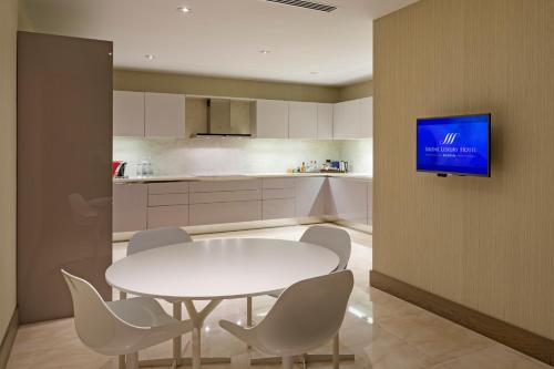a kitchen with a table and chairs and a tv on a wall at Sirene Luxury Hotel Bodrum in Yalıkavak